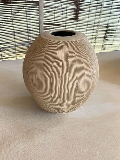 A collection of large, unglazed vases in various shapes and sizes. Each one is thrown on the wheel and showcases a different form, from classic curves to textured surfaces.