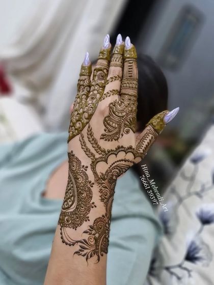 A stylish Indo-Arabic design applied on the back of the hand. The pattern extends from the fingers to the wrist in a single, flowing piece.