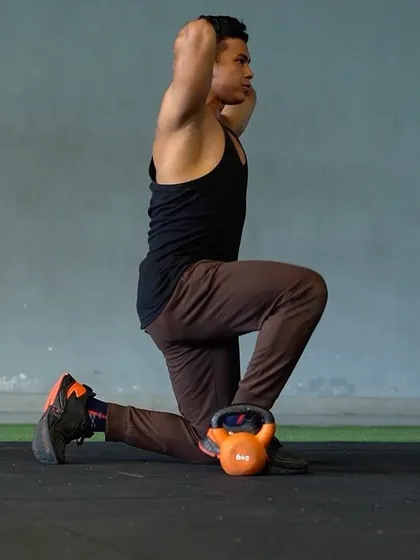 A kettlebell-assisted hip flexor stretch. This exercise helps improve flexibility and core strength, which is vital for posture and athletic performance.
