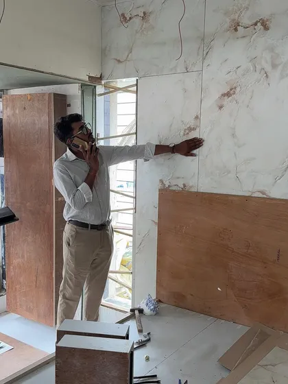 On the phone, coordinating logistics while inspecting the panel installation on-site.