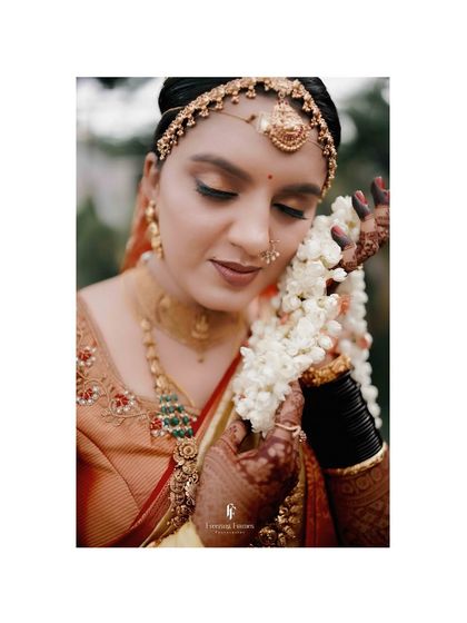 A close-up of a bride, her face framed by a garland, capturing her serene beauty.