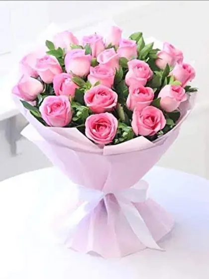 A fuller bouquet of beautiful pink roses, wrapped in simple lilac paper with a white ribbon. This arrangement is perfect for birthdays, thank you gifts, or Mother's Day.