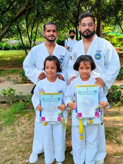 Two of our youngest students proudly holding their certificates after successfully passing their belt exam.