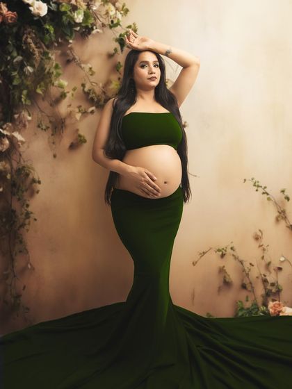 A stunning portrait in a dark green two-piece gown against a rustic, ivy-covered wall. This look is both earthy and glamorous.