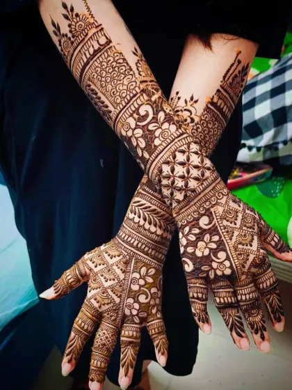 A creative pose showing both the front and back of the hands, highlighting the continuity of the intricate patterns.