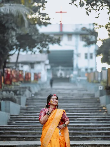 A wide shot of the bride at her Haldi ceremony, with a church in the background.