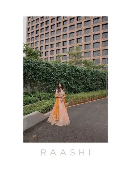 A stylish portrait of Raashi at her Haldi ceremony, set against a modern building. This shot contrasts traditional attire with contemporary architecture, creating a unique and fashionable image.