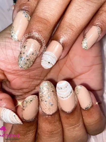 A chic and neutral design with a touch of sparkle. This set uses a nude base with a silver glitter ombré at the tips, and adds interest with white-striped accent nails.