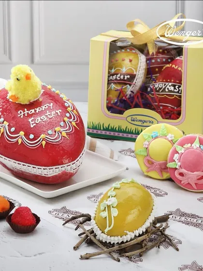 A colourful display of our Easter marzipan collection. It includes a large, hand-decorated marzipan egg, smaller eggs in a nest, and beautifully crafted Easter-themed cookies.