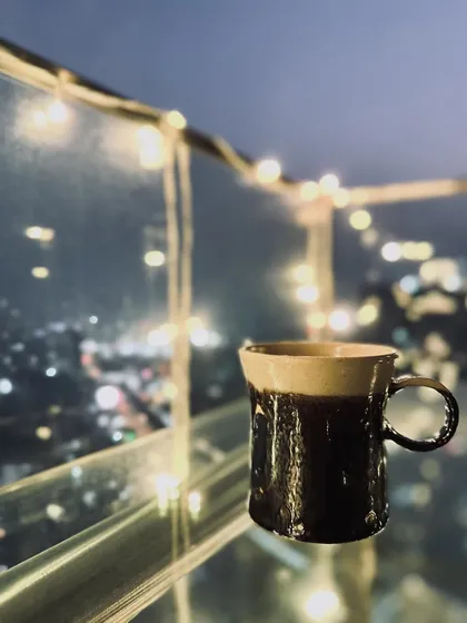 A mug from our Shibui Collection's "metallic verse" series, set against a sparkling city view. Perfect for a festive cup of hot chocolate.