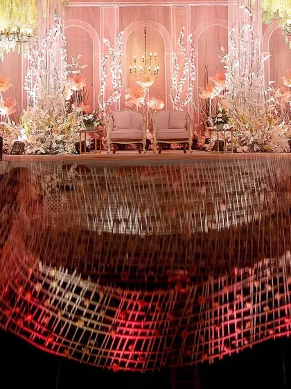 Another reflection shot that captures the grandeur of the reception stage and the intricate ceiling art. The design creates a multi-layered visual experience for guests.
