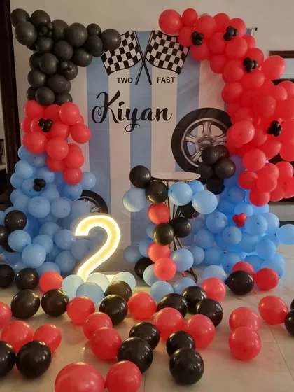 A wide shot showing the balloons scattered on the floor, adding to the fun and immersive feel of the car-themed party.