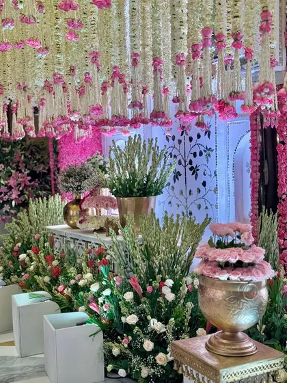 A detail shot of the welcome area, where a garden of blooms cascades from above. Vibrant florals, lush greens, and golden accents come together to create the dreamiest setting. 🪷