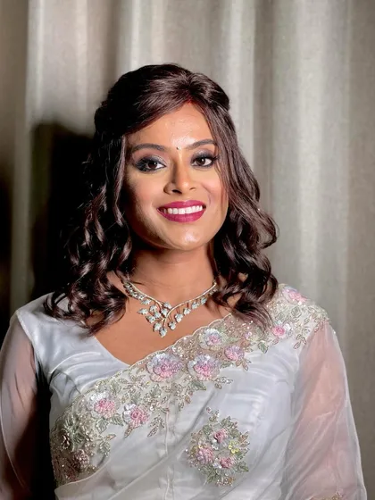 A happy client showing off her gorgeous hair and makeup, perfect for a party or special occasion.