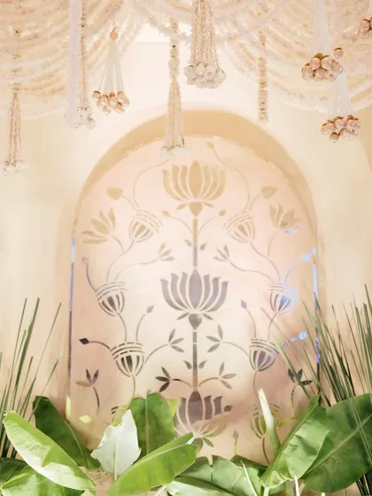 A close-up of the lotus motif panel, a central design element that adds a layer of spiritual and cultural significance to the wedding stage. The surrounding greenery enhances its natural beauty.
