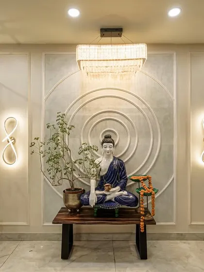 Another view of the Buddha statue from image 153, highlighting the modern infinity-shaped wall lights and crystal chandelier.