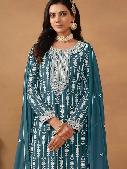This teal salwar kameez is a classic. The white thread embroidery creates a stunning contrast, and the sharara pants add a modern, fashionable touch.