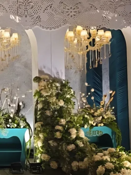 Another angle of the elegant white and teal decor, highlighting the beautiful chandeliers and intricate lace-like ceiling panels.