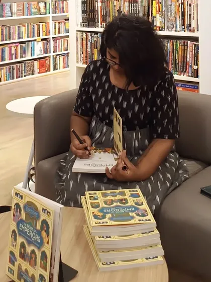 The author at work! Ashwitha Jayakumar signs copies of her book for eager readers. Getting a personalized copy makes the reading experience even more special.