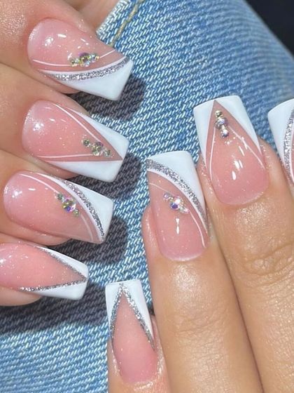 A modern take on the French manicure with sharp white V-tips and a sparkling silver glitter line.