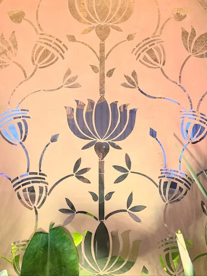 A close-up of the intricate lotus design on the central wall panel, a symbol of purity and beauty that perfectly complements the all-white wedding theme.