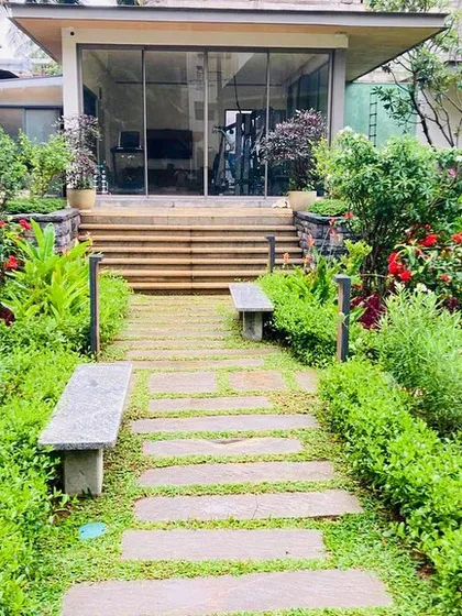 A successful landscape invites you to explore. Here, we designed a winding stone path that leads to a secluded seating area, surrounded by lush, layered plantings to create a sense of a private garden sanctuary.
