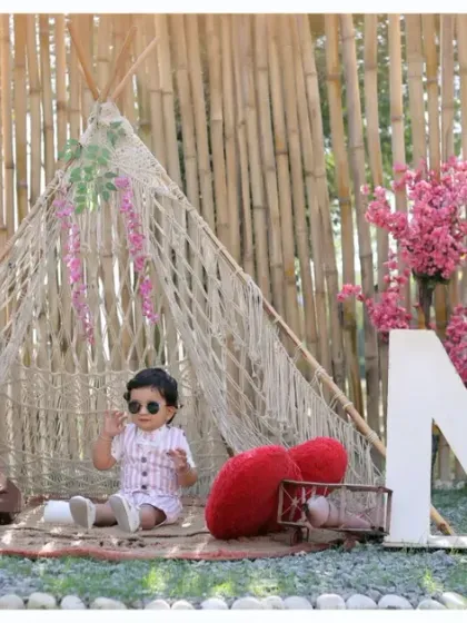 A wide shot of our outdoor boho first birthday setup, showcasing the full scene with a teepee, 'ONE' letters, and beautiful floral details.