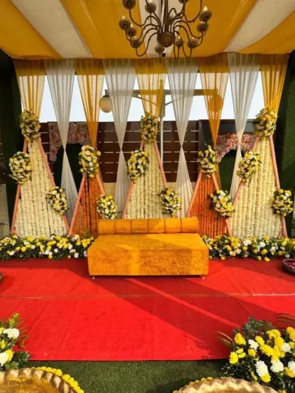 An elegant take on the Haldi ceremony, with white and yellow floral arrangements and a beautiful chandelier. The personalized welcome sign adds a custom touch to the celebration.