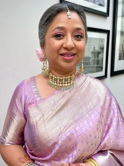 This mother of the bride looks absolutely radiant in a lovely lavender saree. Her makeup is fresh and youthful, with a soft pink flush on her cheeks.