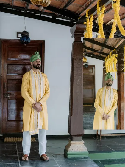 A creative portrait of the groom with his reflection, captured in a traditional setting.