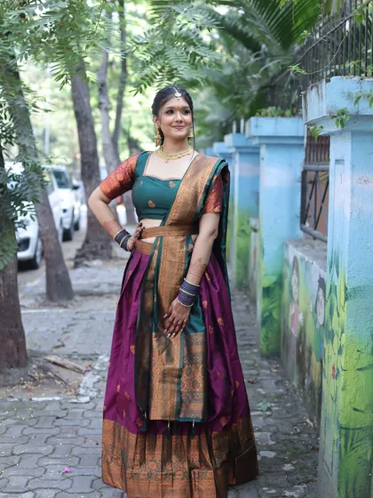 A full-length shot of a client in a traditional South Indian half-saree. The makeup is classic and elegant, perfect for the occasion.