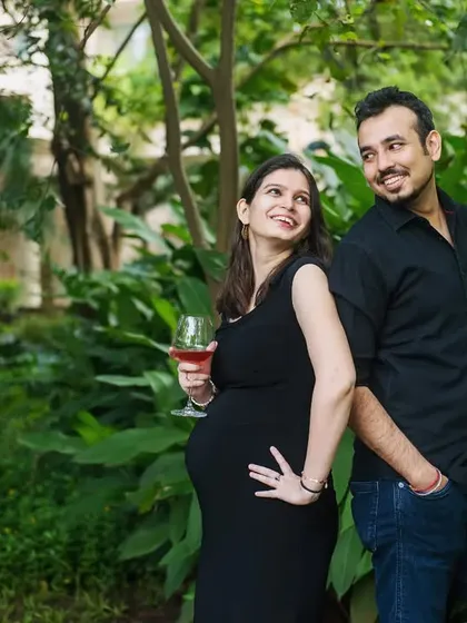 Cheers to the future. A fun and playful shot of the couple, with the mom-to-be holding a glass of juice and the dad-to-be holding a baby bottle.