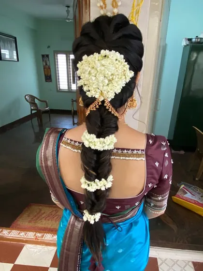 A neat and tidy traditional braid adorned with fresh jasmine flowers. This classic hairstyle is perfect for any South Indian wedding ceremony, from the engagement to the Muhurtham.