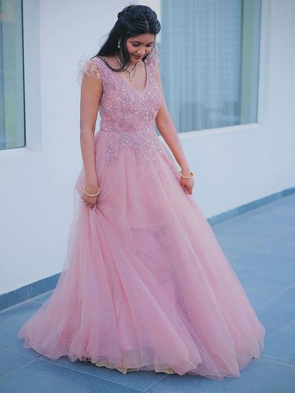 This baby pink ball gown is a dream to wear, with its light, airy tulle skirt and subtly sparkling bodice. The feather details on the shoulders add a touch of modern glamour, making it a popular choice for evening events.