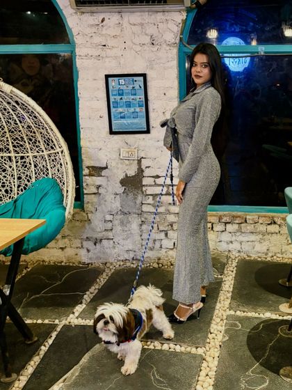 Posing for the camera. The bond between this owner and her dog is as clear as their fashion sense.