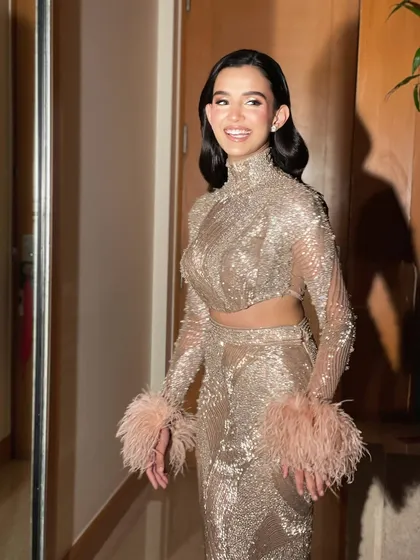 A candid shot of a happy client. Her vintage inspired waves with a deep side part are perfect for her sequined, feathered outfit, creating a cohesive, glamorous look.
