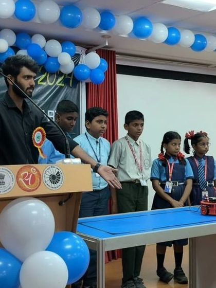 An instructor explains the workings of a robot to a group of young students at an Innovation Fair. These outreach activities are central to our mission of making tech education accessible.