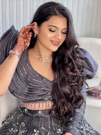 Adjusting her earring, this client shows off her beautiful side profile and the flawless finish of her makeup.