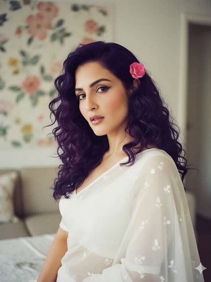 A slightly bolder version of the classic look, with a sharp winged liner and defined curls. The pink flower adds a touch of romance to this beautiful portrait.