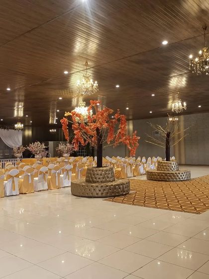 The interior of a banquet hall with unique tree-like centerpieces. We can provide creative decor solutions to make your venue stand out.