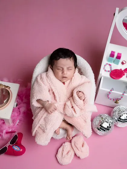 A pampering spa day for this little beauty. Dressed in a fluffy pink bathrobe, she's surrounded by a miniature vanity, disco balls, and other fun, girly props.