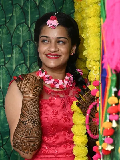 A candid shot of a happy bride, her intricate mehendi on full display. This is a celebration of love, tradition, and personal beauty.