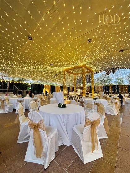 A breathtaking dining setup under a massive canopy of fairy lights, creating the feeling of dining under a starry sky for a magical reception dinner.