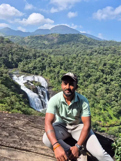 A moment of peace, sitting on a rock overlooking the falls and the surrounding green valley.