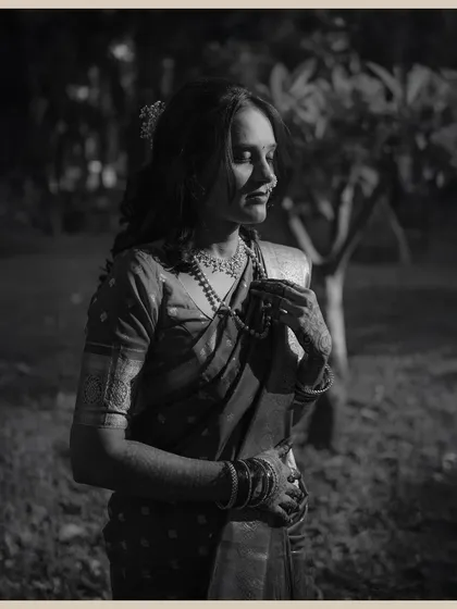 A moody, black and white portrait of the bride in a quiet, contemplative moment. The dramatic lighting creates a beautiful, artistic feel.