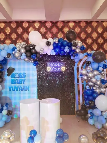 A closer look at the main backdrop for the Boss Baby party, with its checkered pattern and "Happy B'day" neon sign.