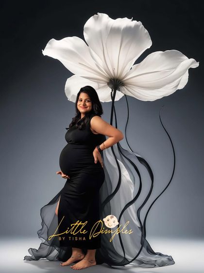 Simple, elegant, and striking. The contrast of the black gown against the giant white flower prop creates a modern and artistic maternity portrait.