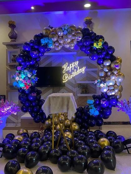A full view of the blue and gold birthday decoration with balloons scattered on the floor.
