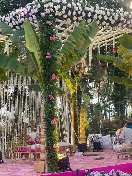 A stunning mandap design incorporating natural elements like palm trees wrapped in flowers. The roof is a beautiful web of jasmine, creating a fragrant and visually unique space for the ceremony.