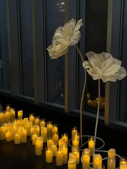 The giant organza flowers and candles set against the evening skyline, creating a dramatic and romantic setting.